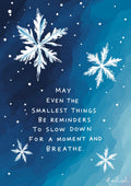 Minimalist blue poster featuring white snowflakes and the quote, “May even the smallest things be reminders to slow down for a moment and breathe.”